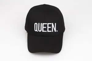 Detailed view of white QUEEN embroidery on a premium black cotton baseball cap