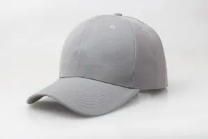 Detail of grey cotton baseball cap showing six-panel stitching and curved brim texture