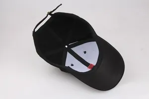 Black cotton baseball cap showing interior structure with white lining and metal buckle