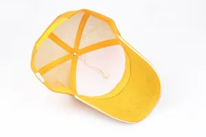 Detalle de gorra trucker de algodón amarillo con rejilla y etiqueta interna Made in China