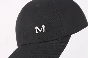 Dettaglio cappello da baseball nero in cotone con logo M in metallo e twill