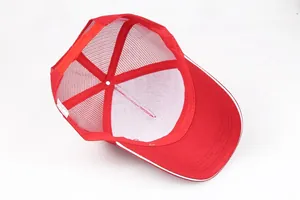 Detalle de gorra trucker roja con cierre snapback y ribete blanco en la visera