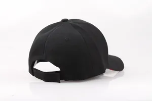 Dettaglio della chiusura in velcro e del bordo rosso sulla visiera del cappello nero