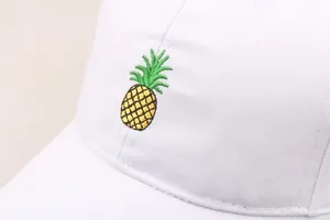 Gros plan d'une broderie d'ananas sur une casquette de baseball en coton blanc de qualité