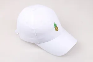Détail en gros plan de la broderie d'ananas colorée sur une casquette en coton blanc