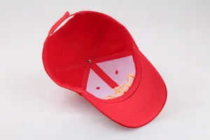 Detail van rode canvas baseballpet met binnenstiksels en verstelbare klittenbandsluiting