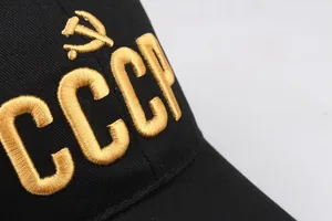 Macro-opname van gouden USSR-borduurwerk met hamer en sikkel op een zwarte pet