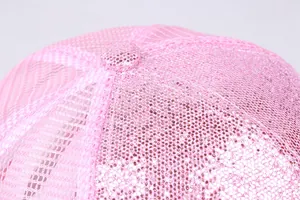 Makro-Detail von rosa Pailletten und atmungsaktivem Mesh-Gewebe auf einer Baseballkappe