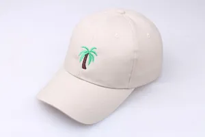 Detailed close-up of palm tree embroidery on a beige cotton baseball cap with stitched brim