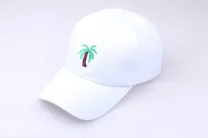 Detailed view of green palm tree embroidery on a minimalist white cotton baseball cap