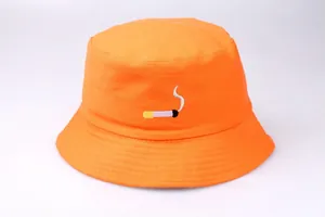 Detailed view of an orange bucket hat with a high-quality embroidered cigarette design