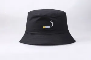 Detailed close-up of cigarette embroidery on a black cotton bucket hat with fine stitching