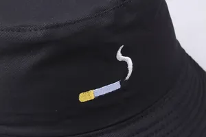 Black cotton bucket hat featuring unique cigarette embroidery design in a minimalist style