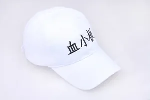 Detailed view of the white cotton baseball cap featuring black Platelet embroidery