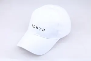 Détail de la broderie noire YOUTH sur une casquette de baseball en coton blanc élégante
