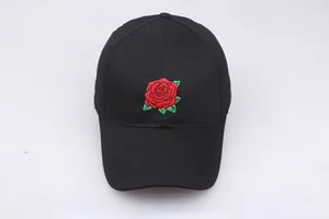 Close-up of intricate red rose embroidery on a black cotton baseball cap with curved brim