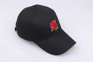 Close-up of red rose embroidery on black cotton baseball cap with detailed stitching