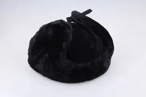Nahaufnahme der dicken schwarzen Pelzmütze mit Ohrenklappen und Zierschleife