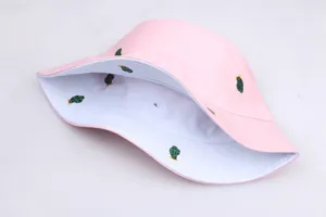 Detailed close-up of pink bucket hat with green cactus embroidery and white inner lining