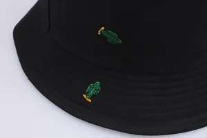 Close-up of green cactus embroidery on high-quality black canvas bucket hat fabric