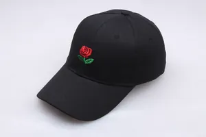 Close-up of vibrant red rose embroidery on a black cotton twill baseball cap fabric