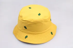 Detailed close-up of green cactus embroidery on a bright yellow cotton bucket hat fabric