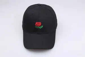 Close-up of red rose embroidery on a black cotton twill baseball cap with curved brim