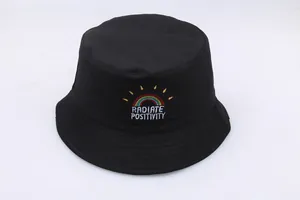 Detail of rainbow sun embroidery and Radiate Positivity text on black canvas bucket hat