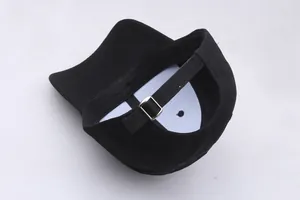 Détail de la boucle métallique réglable et de la sangle en coton noir au dos de la casquette