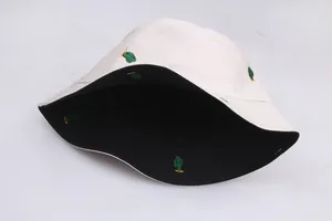 Detail view of double-sided bucket hat with green cactus embroidery on black and white fabric