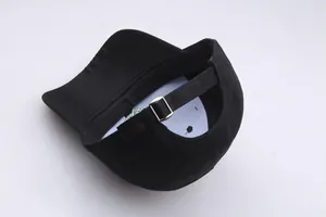 Detail of adjustable metal buckle and black fabric strap on cotton baseball cap