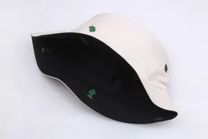 Detail of reversible bucket hat with cactus embroidery on beige and black canvas fabric