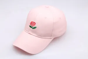 Close-up of pink baseball cap with detailed red rose embroidery and green leaf accents