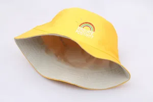 Close-up of yellow bucket hat featuring rainbow embroidery and Radiate Positivity text