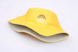 Detail of yellow cotton bucket hat with rainbow embroidery and positive text