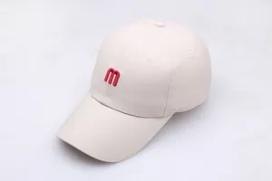Detailopname van rood M-letter borduursel op een hoogwaardige gebroken witte pet