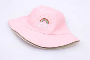 Close-up of rainbow embroidery and Radiate Positivity text on a pink bucket hat