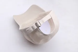 Detail van de verstelbare metalen gesp en katoenen textuur op de beige baseballpet