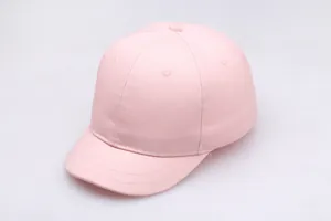 Detail der hellrosa Baumwollstruktur einer Baby-Baseballkappe mit weichem kurzem Schirm