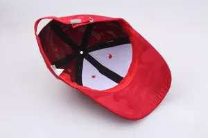 Detail view of red baseball cap interior with camouflage texture and metal buckle