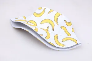 Detailed close-up of white bucket hat with vibrant yellow banana print and cotton texture
