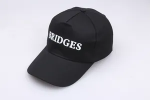 Nahaufnahme der schwarzen Baumwoll-Baseballkappe mit weißer BRIDGES Bestickung
