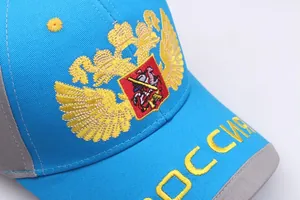 Detailansicht der goldenen Doppeladler-Stickerei auf einer hellblauen Baseballkappe