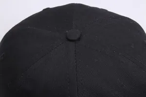 Detailansicht einer schwarzen Baumwollkappe mit Sechs-Panel-Naht und Knopf von oben