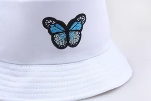 Detail der blauen Schmetterlingsstickerei auf weißem Baumwollhut mit verstärkten Nähten