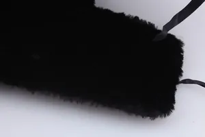 Detail of plush black thermal material and satin ribbon ties on a warm trapper hat