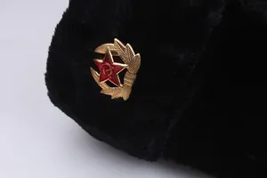 Detailed close-up of winter ushanka hat featuring a golden Soviet-style metal badge