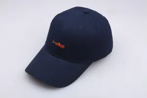 Detail of navy blue twill baseball cap showing precise orange whale embroidery on the front