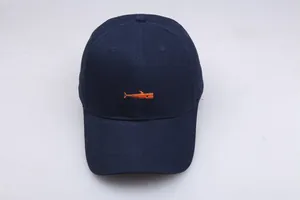 Detailed view of navy blue cotton baseball cap featuring bright orange whale embroidery