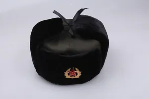 Detail of Russian ushanka hat with green canvas, faux fur trim and Soviet emblem